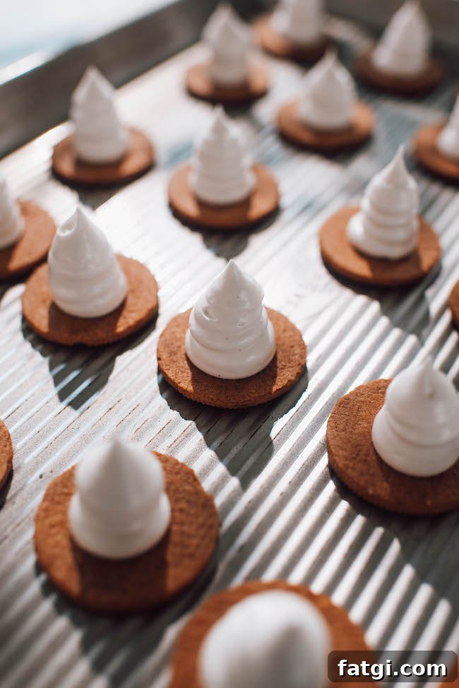 Halloween Witch Hat Smores Cupcakes 10 Piping marshmallow frosting onto cookies for witch hats