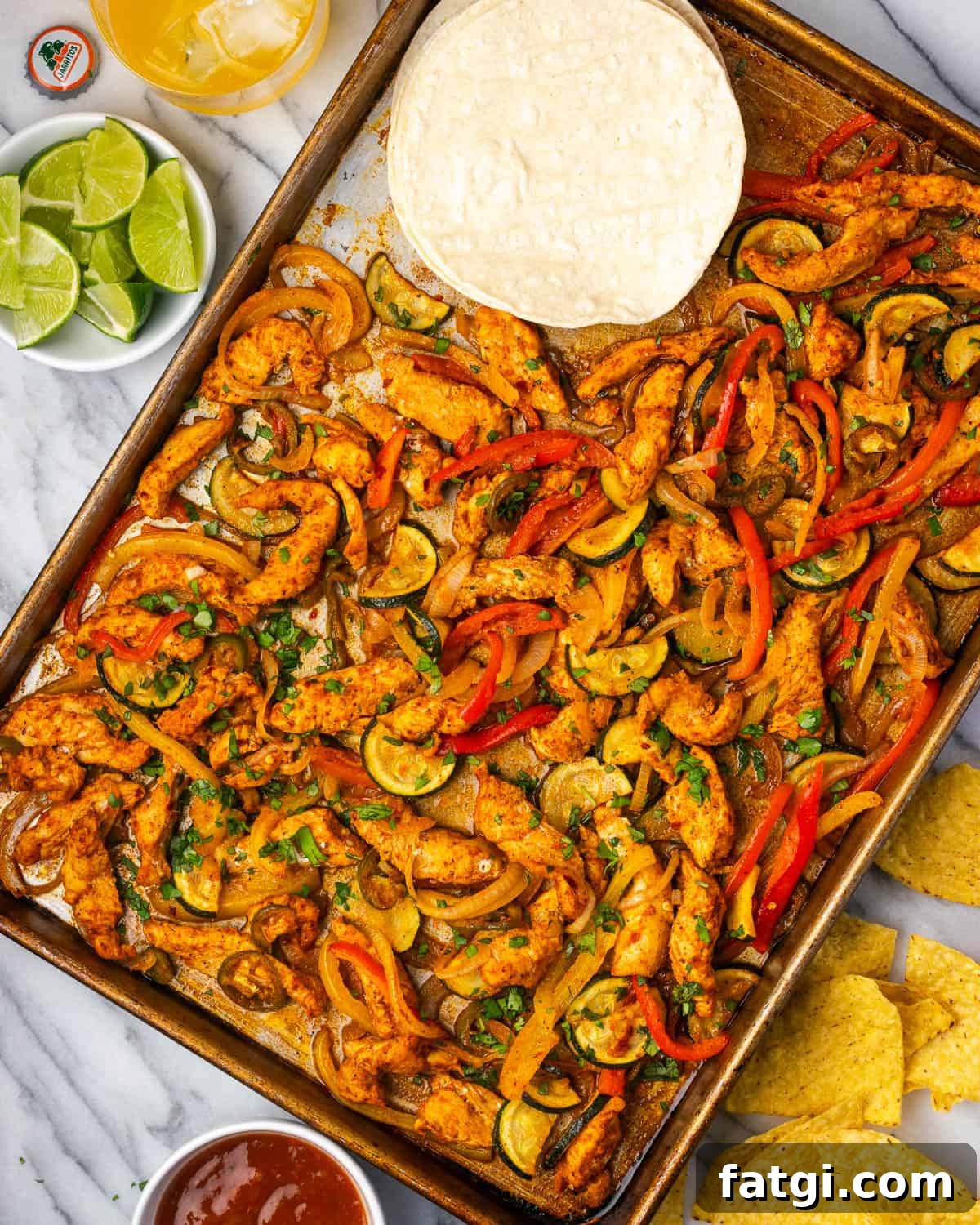 Sheet Pan Chicken Fajitas with Peppers and Onions 2 Sheet pan chicken fajitas served with tortillas, corn chips and salsa.