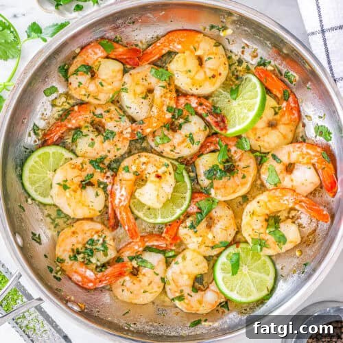 Cilantro lime shrimp served in a large skillet with slices of fresh lime.