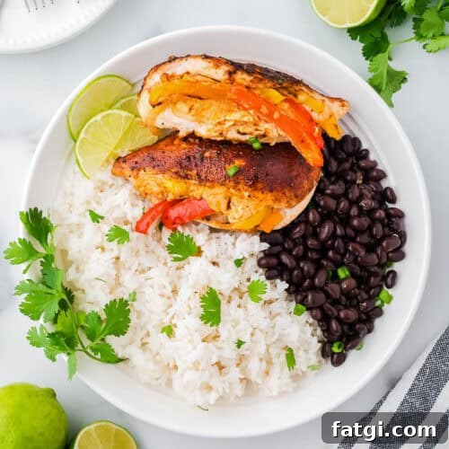 Two fajita stuffed chicken breasts served with white rice and black beans.