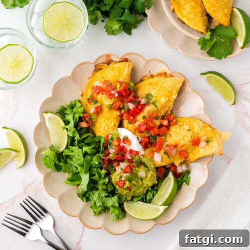 Three crispy chicken tacos served with lettuce, tomato and sour cream.