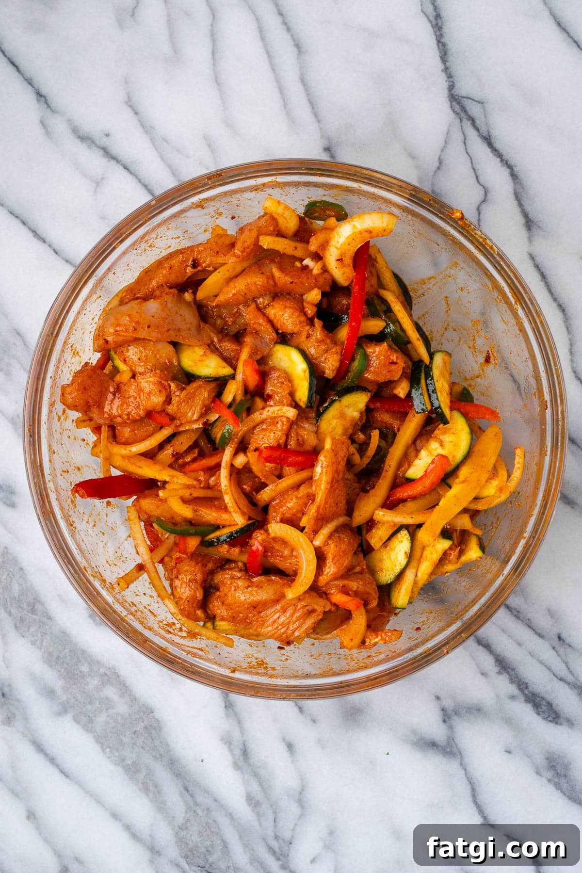 Sheet Pan Chicken Fajitas with Peppers and Onions 6 Chicken fajitas marinating in a large bowl.