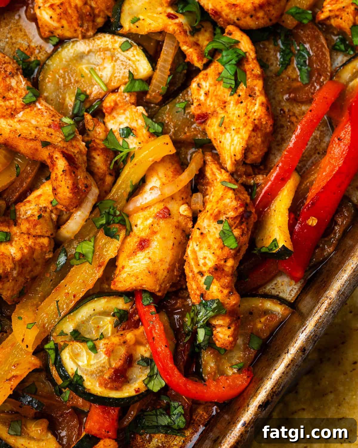 Sheet Pan Chicken Fajitas with Peppers and Onions 8 Freshly baked chicken fajitas on a metal sheet pan.
