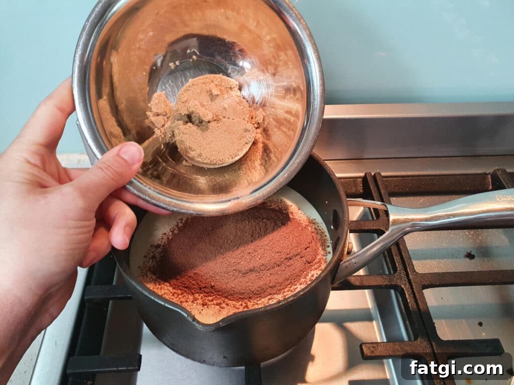 adding brown sugar to ice cream mix in pot on stove.