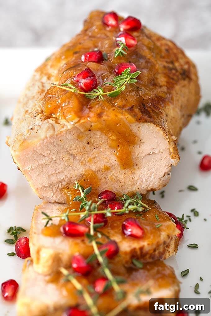 Instant Pot Pork Tenderloin with Balsamic Apples 2 Balsamic Apple Pork Tenderloin garnished with pomegranate and thyme on a white plate