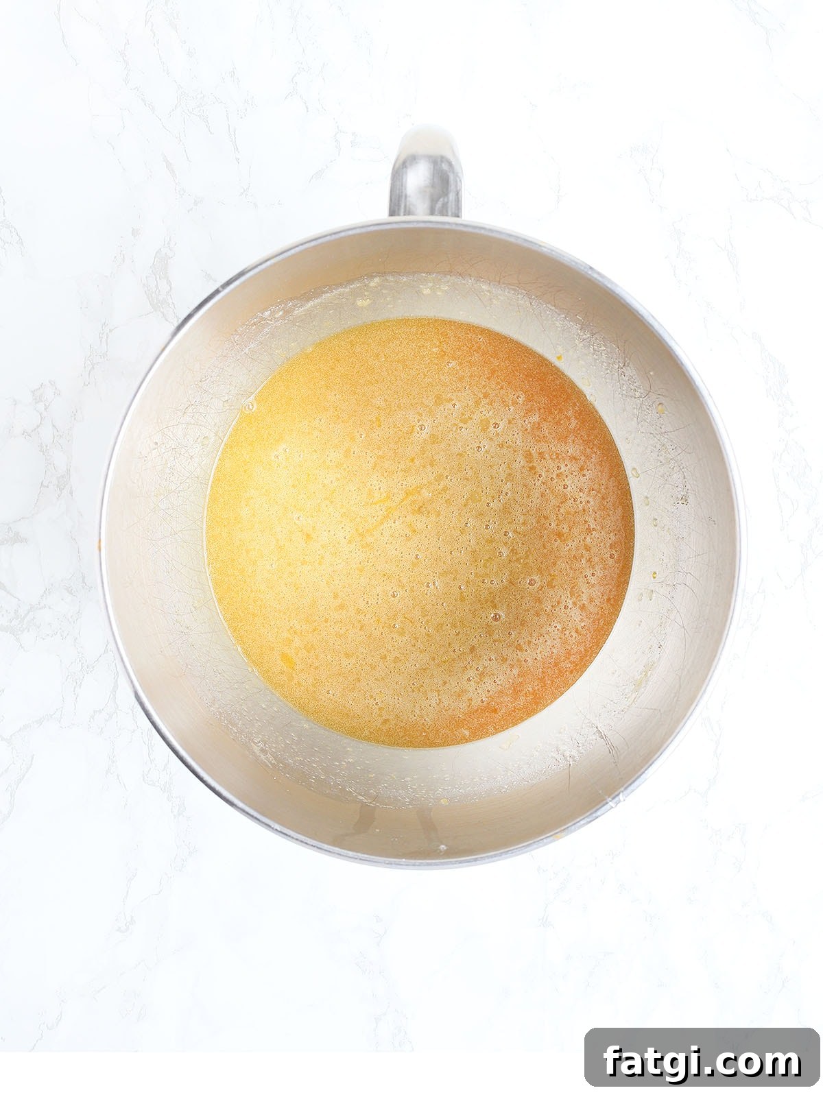 Eggs, melted butter, corn syrup, bourbon, brown sugar and vanilla mixed in a metal mixing bowl.