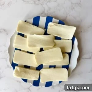 Cheese cut up into rectangles on a plate.