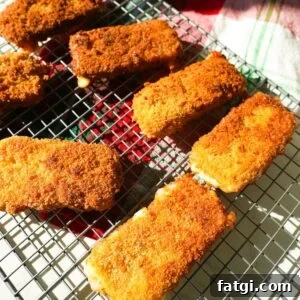 Golden mozzarella sticks on a wire rack.
