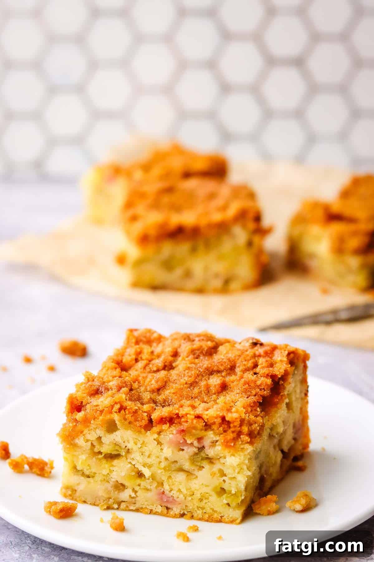 a square slice of rhubarb coffee cake on a plate