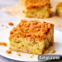 A piece of rhubarb crumb coffee cake on a white plate.