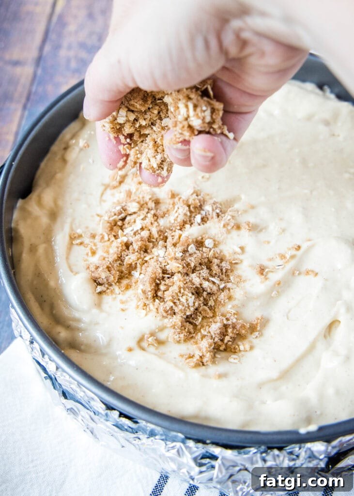 sprinkling streusel topping over cheesecake