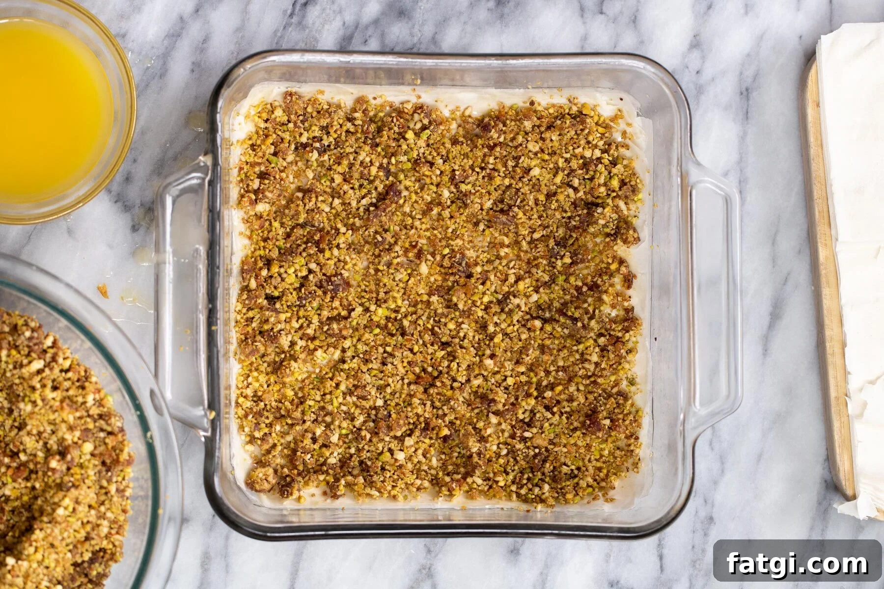 Vegan Baklava with Date and Nut Filling 12 nuts and phyllo pastry being layered to make vegan baklava
