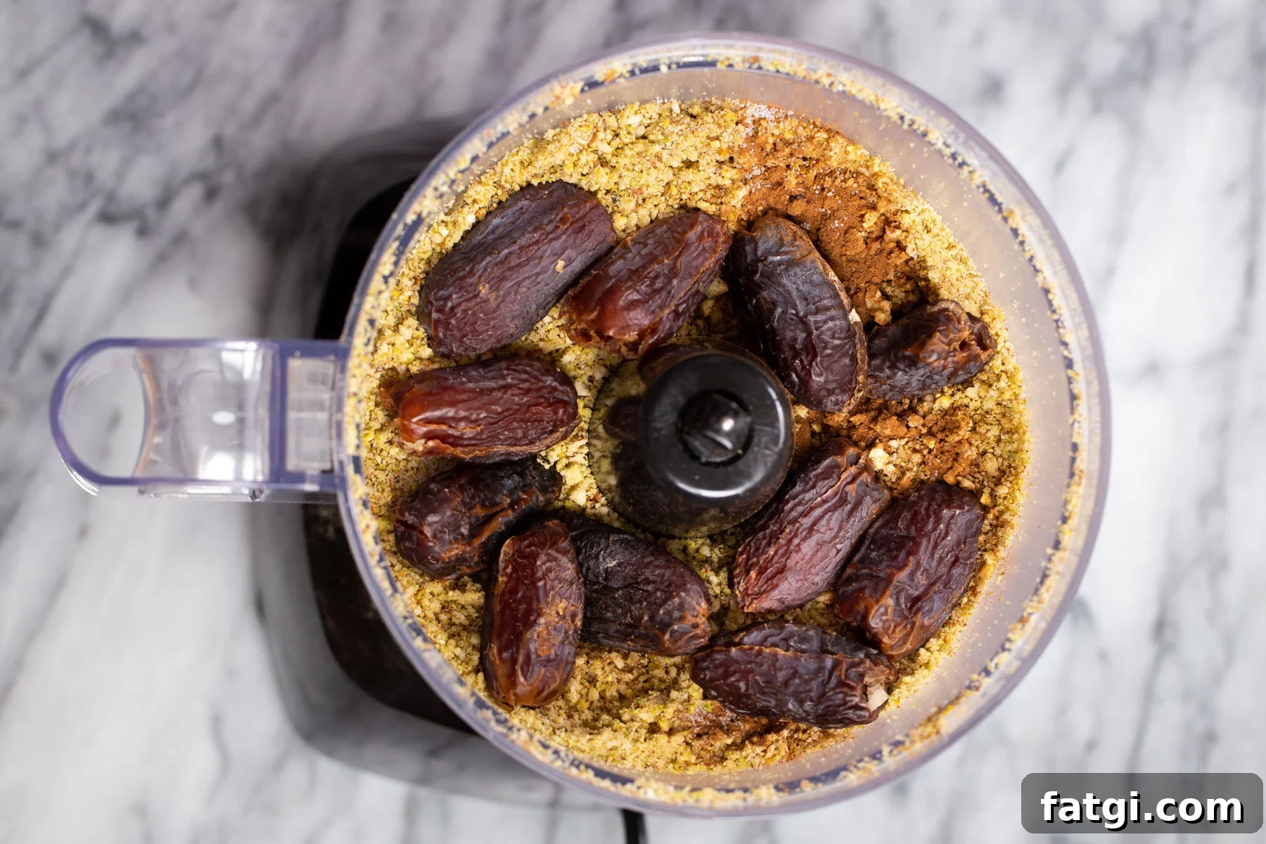 Vegan Baklava with Date and Nut Filling 9 dates being added to ground nuts in a food processor