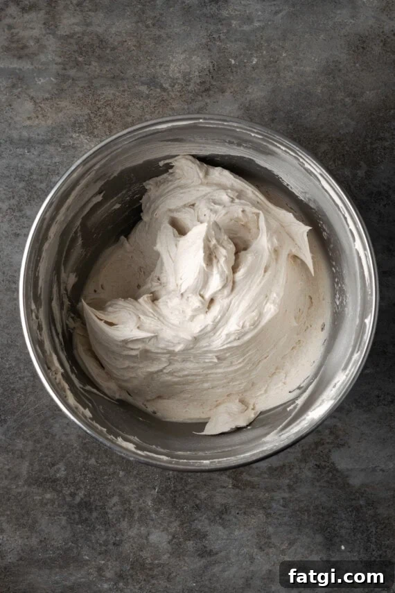 Cinnamon buttercream frosting in a metal mixing bowl.