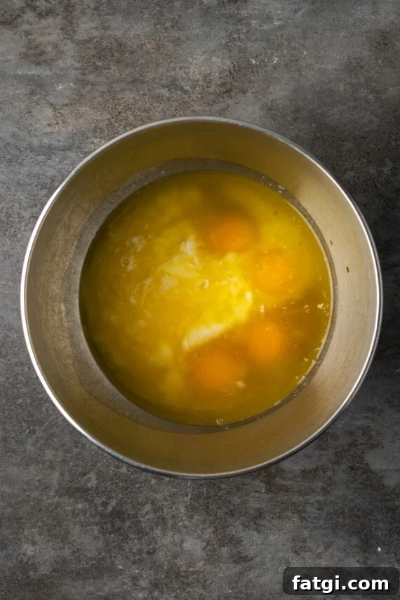 Wet cupcake ingredients combined in a metal mixing bowl.
