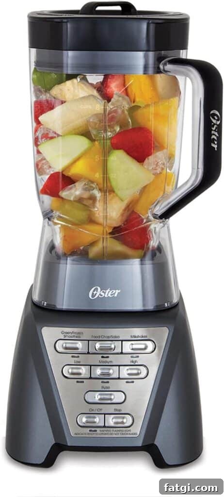 A blender with the word Oster on the handle and full of fruit and ice. 