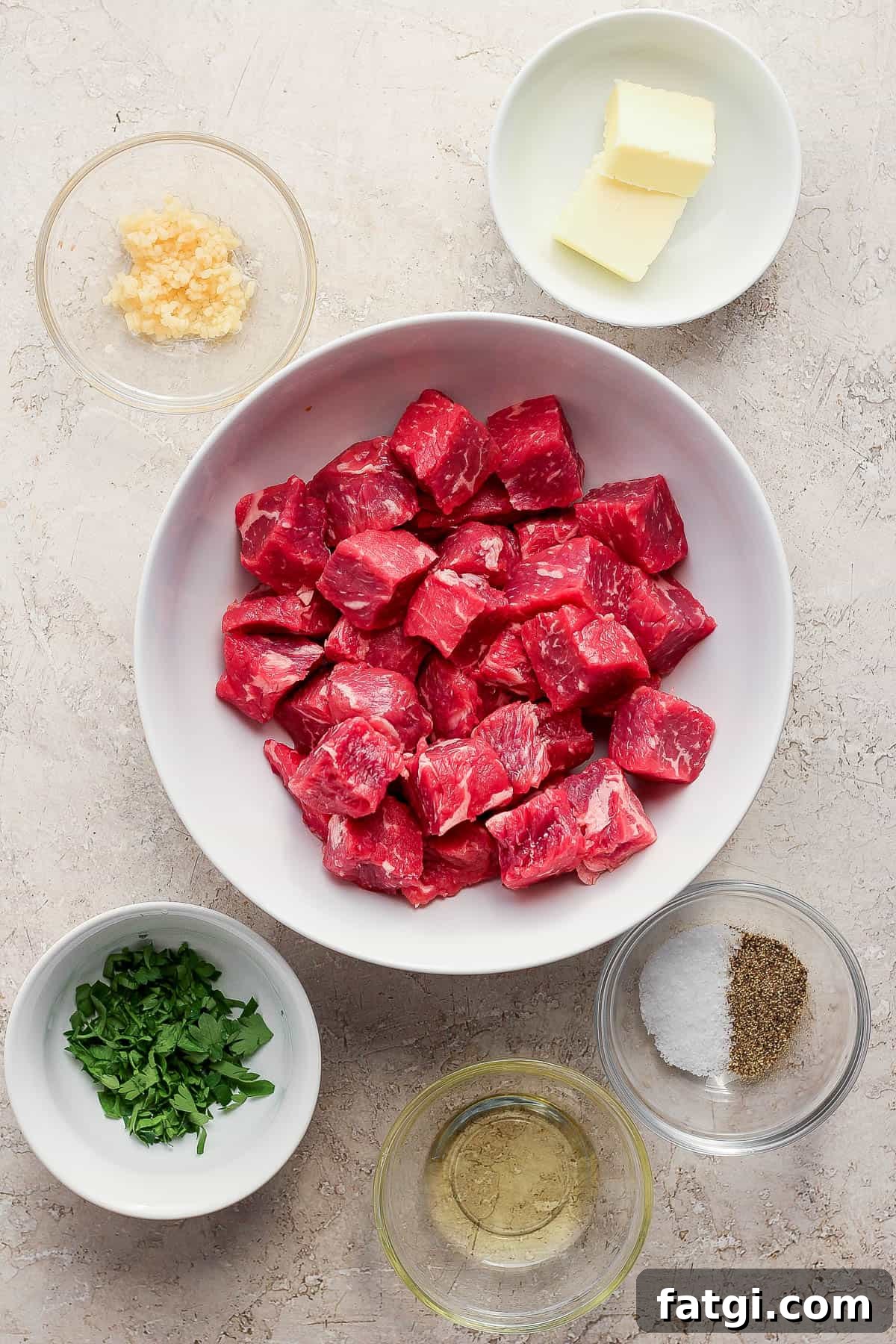 Garlic Butter Steak Bites Recipe 3 Ingredients for garlic butter steak bites in separate bowls.