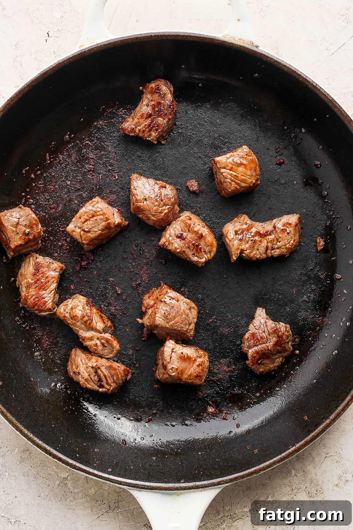 Garlic Butter Steak Bites Recipe 5 Some steak bites searing in a cast iron skillet.