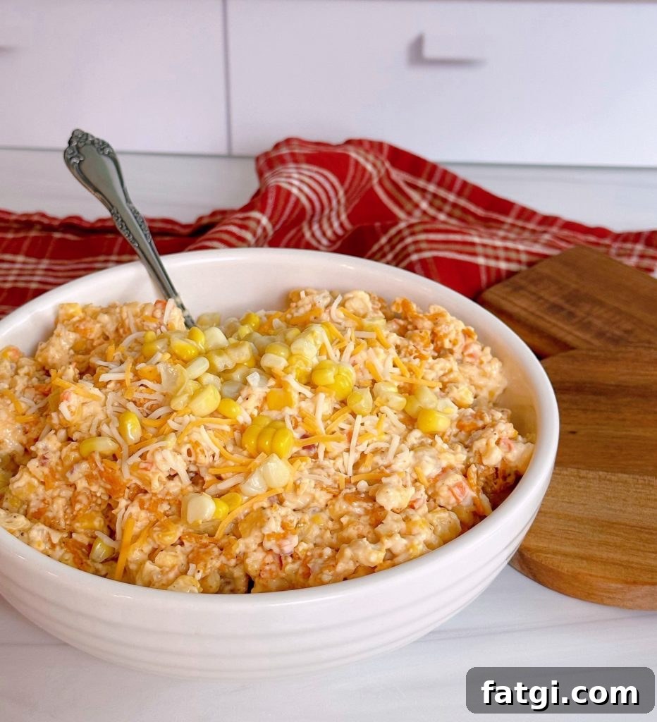 Frito Corn Salad with Cheddar and Chili Cheese Chips 2 Frito Corn Salad in a white serving bowl with a spoon.