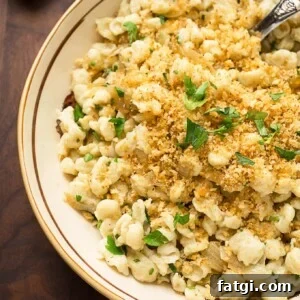 Herbed Spaetzle with Caramelized Onions 3 spaetzle in an invory serving bowl garnished with bread crumbs and parsely