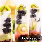 blackberry kiwi mojito recipe garnished with a cocktail pick of blackberries and a kiwi round