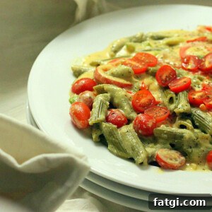 Vegan Chipotle Habanero Spinach Penne with Cashew Cream 5 A white shallow bowl filled with spinach penne with red bell peppers