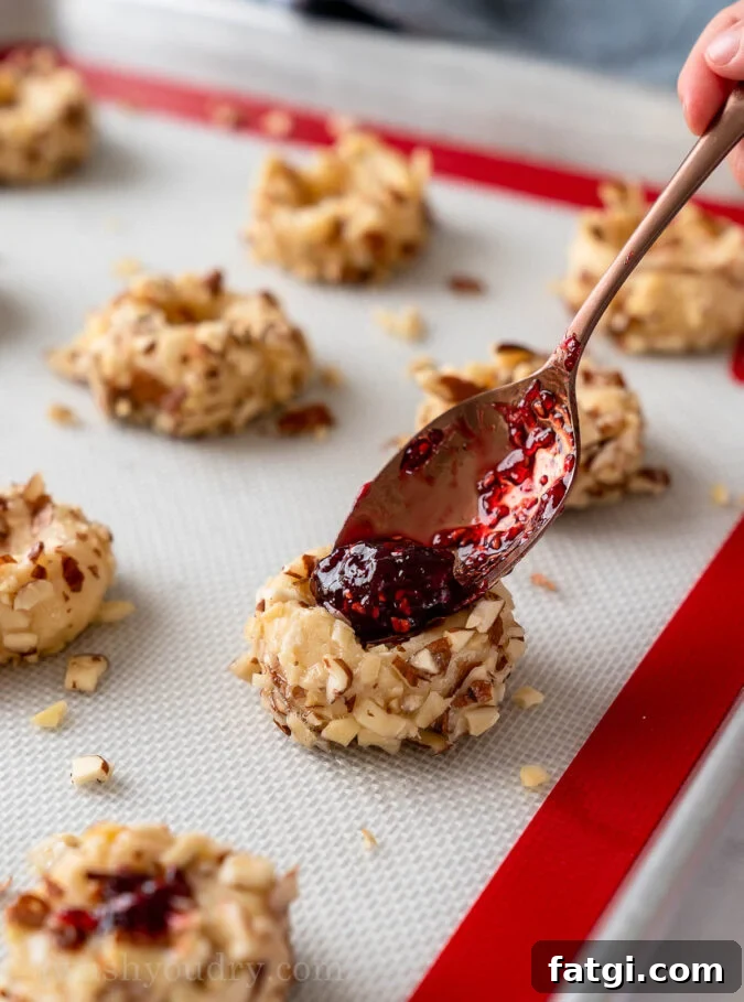 filling cookie with raspberry preserves and almonds
