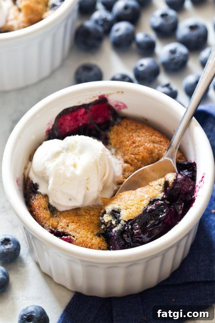 Mini Blueberry Cobbler for Two 2 Blueberry Cobbler in a ramekin with spoon digging in