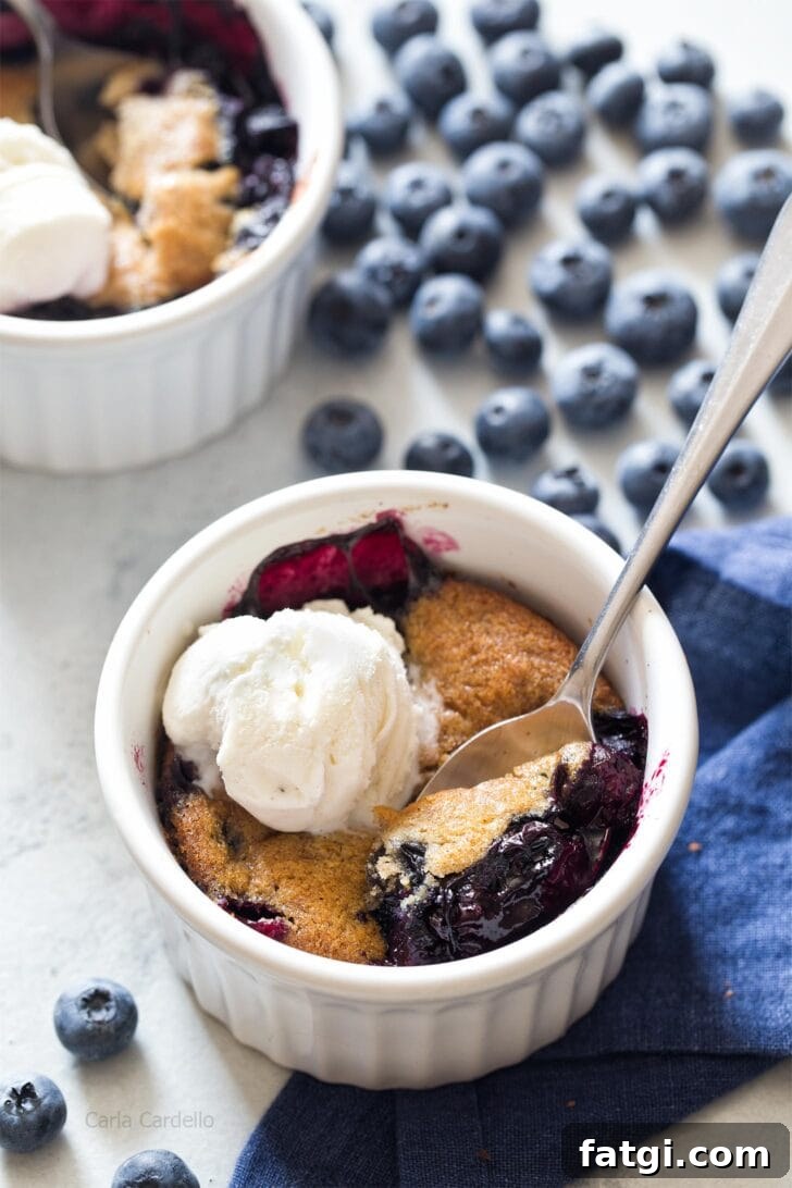 Mini Blueberry Cobbler for Two 6 Blueberry Cobbler in a ramekin with spoon digging in