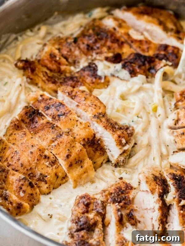 Linguine pasta in a cream sauce topped with chopped seasoned chicken breasts