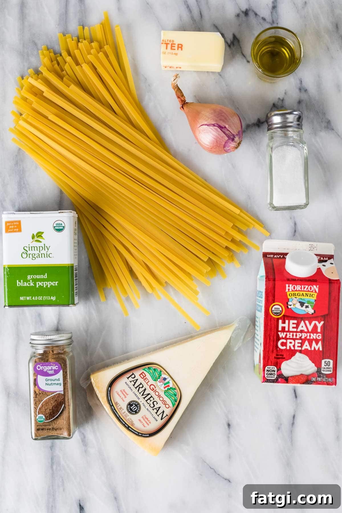 Overhead view of ingredients including fettuccine, parmesan, heavy cream, and more.