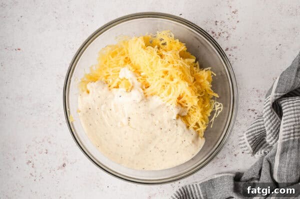 Spaghetti Squash Alfredo with Creamy Garlic Parmesan Sauce 10 roasted spaghetti squash strands with alfredo sauce separate in glass mixing bowl