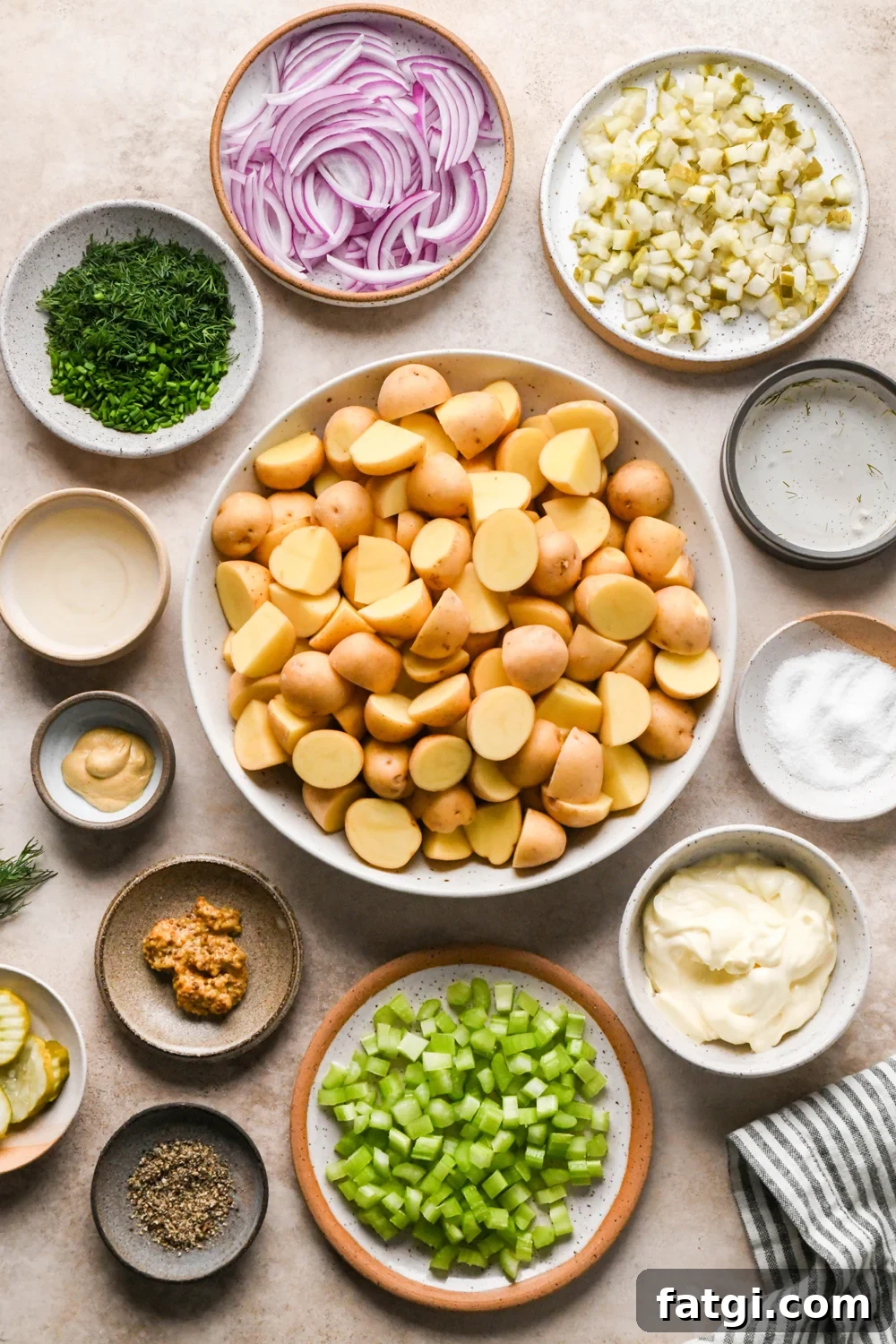 Ingredients to make Dill Pickle Potato Salad with Creamy Dill Dressing in various ceramics on a light creamy brown backdrop.