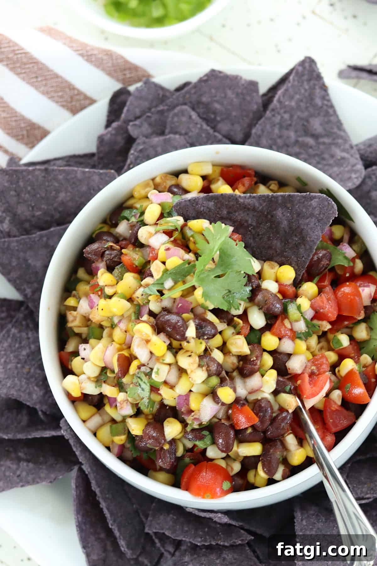 Mexican corn and black bean salsa in a bowl with tortilla chips.