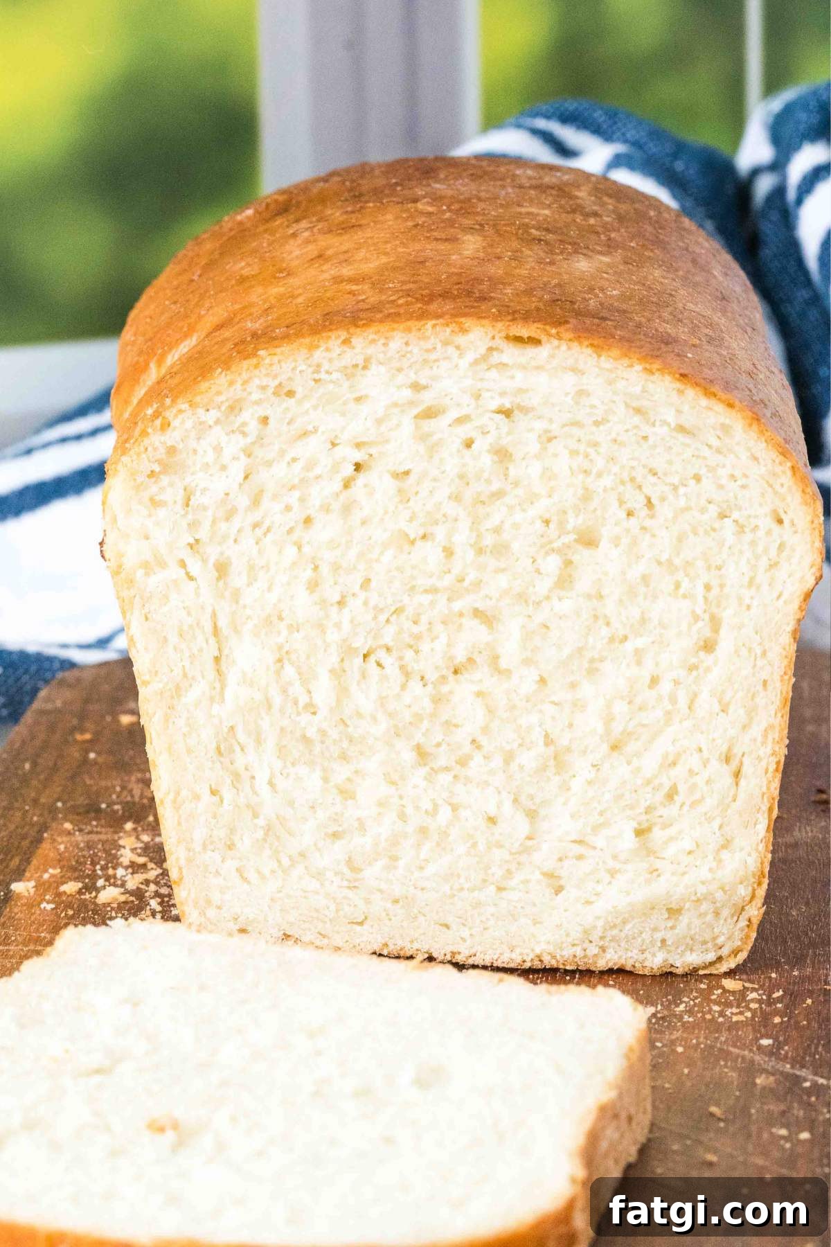 Overnight Sandwich Bread Recipe with Minimal Kneading 2 finished sandwich loaf with blue and white towel.