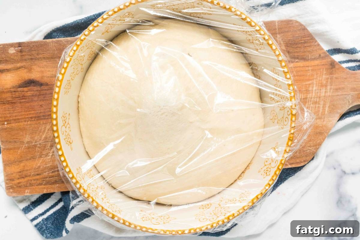 Overnight Sandwich Bread Recipe with Minimal Kneading 5 risen bread dough in a large bowl.