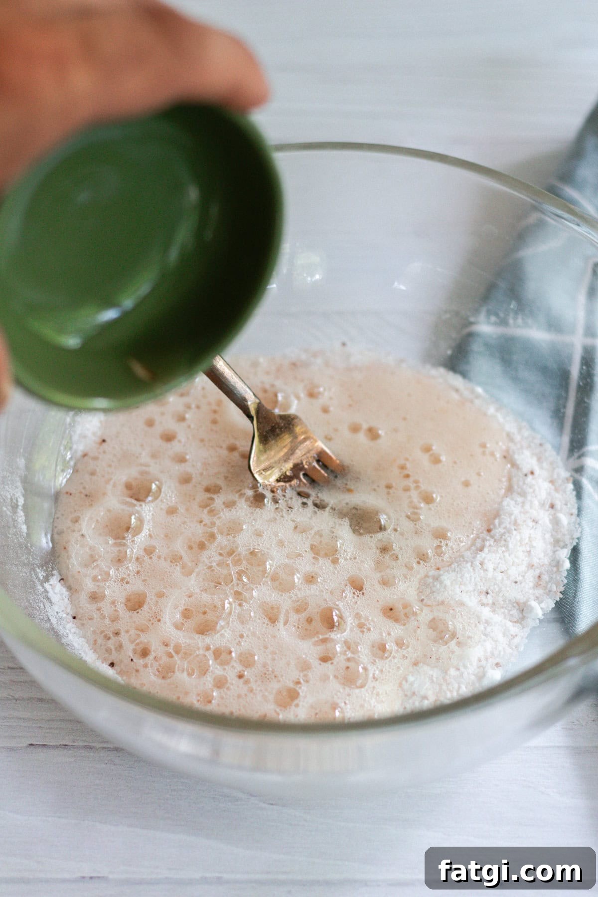 Detox Foot Soak Recipe for Tired Aching Feet 6 Adding apple cider vinegar to the bowl of ingredients and stirring it with a fork.