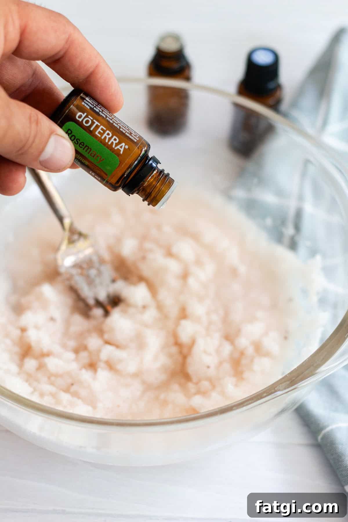 Detox Foot Soak Recipe for Tired Aching Feet 7 Adding essential oils for the foot bath mixture in a glass bowl.