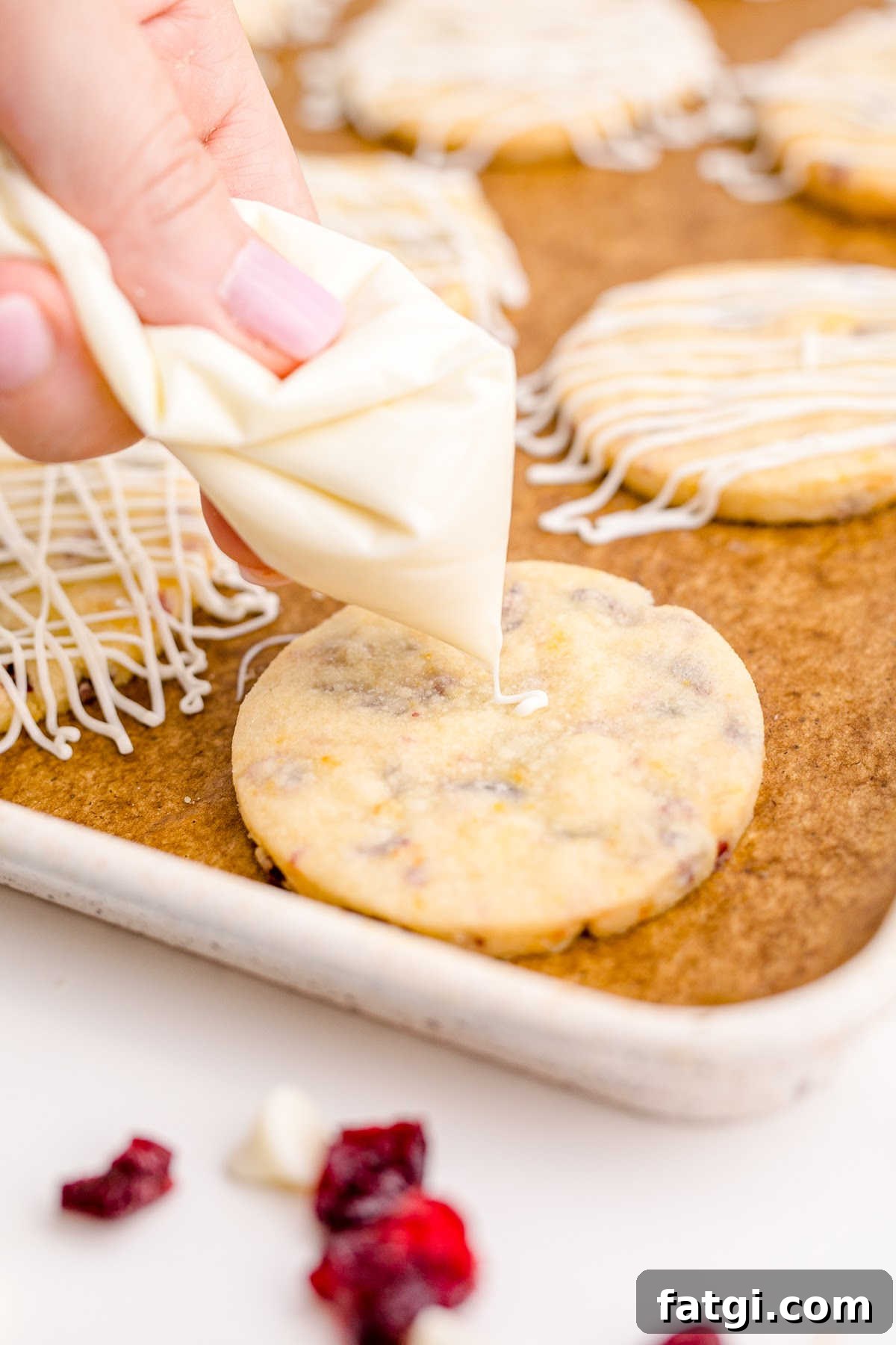 White chocolate being drizzled onto a cooled cookie.
