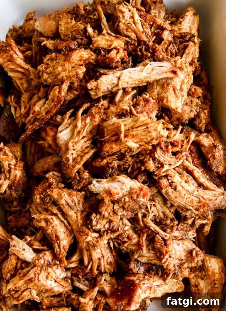Oven roasted pulled pork in a white casserole dish