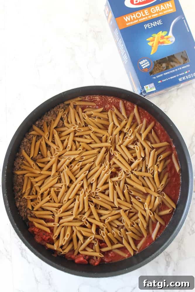 One-skillet baked ziti with mozzarella, ricotta cheese, ground beef, tomatoes, and whole-grain pasta