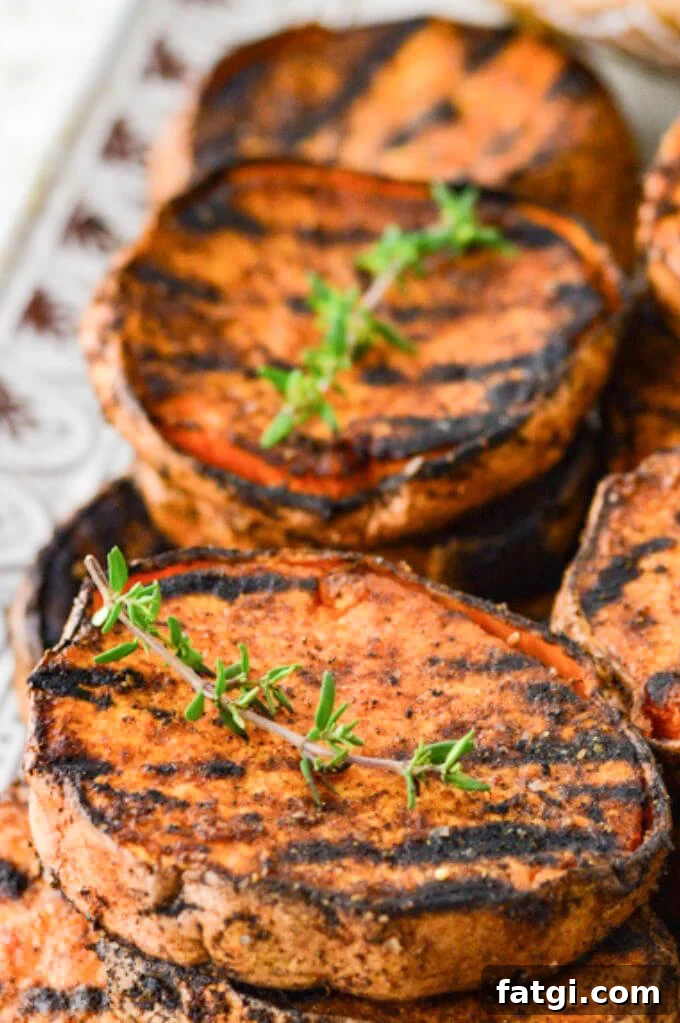 A grilled sweet potato round with a sprig of thyme on it.