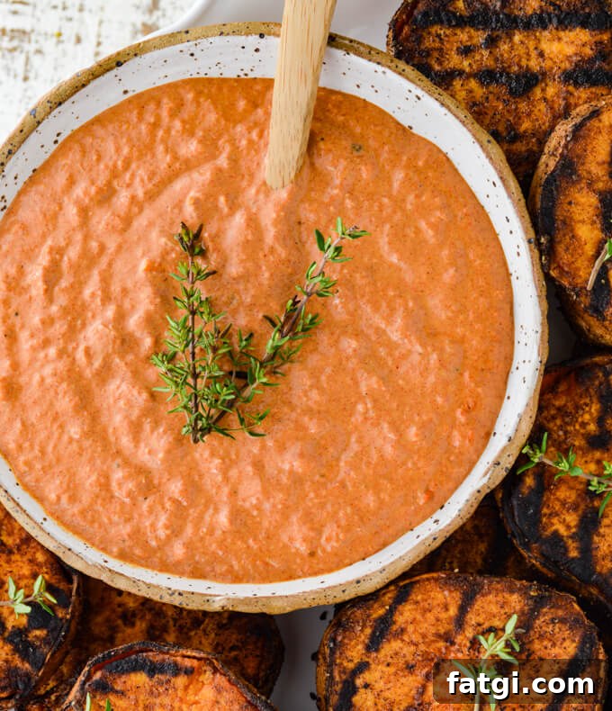 A bowl of smokey dipping sauce with grilled sweet potato rings sitting next to it.
