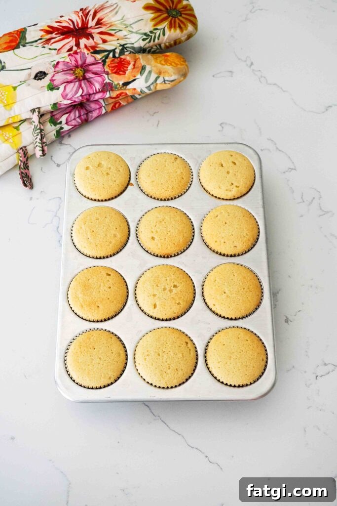 Fully baked vanilla bean cupcakes in a muffin pan.