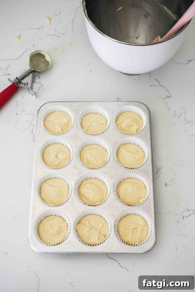 Unbaked vanilla bean cupcakes in a muffin pan.