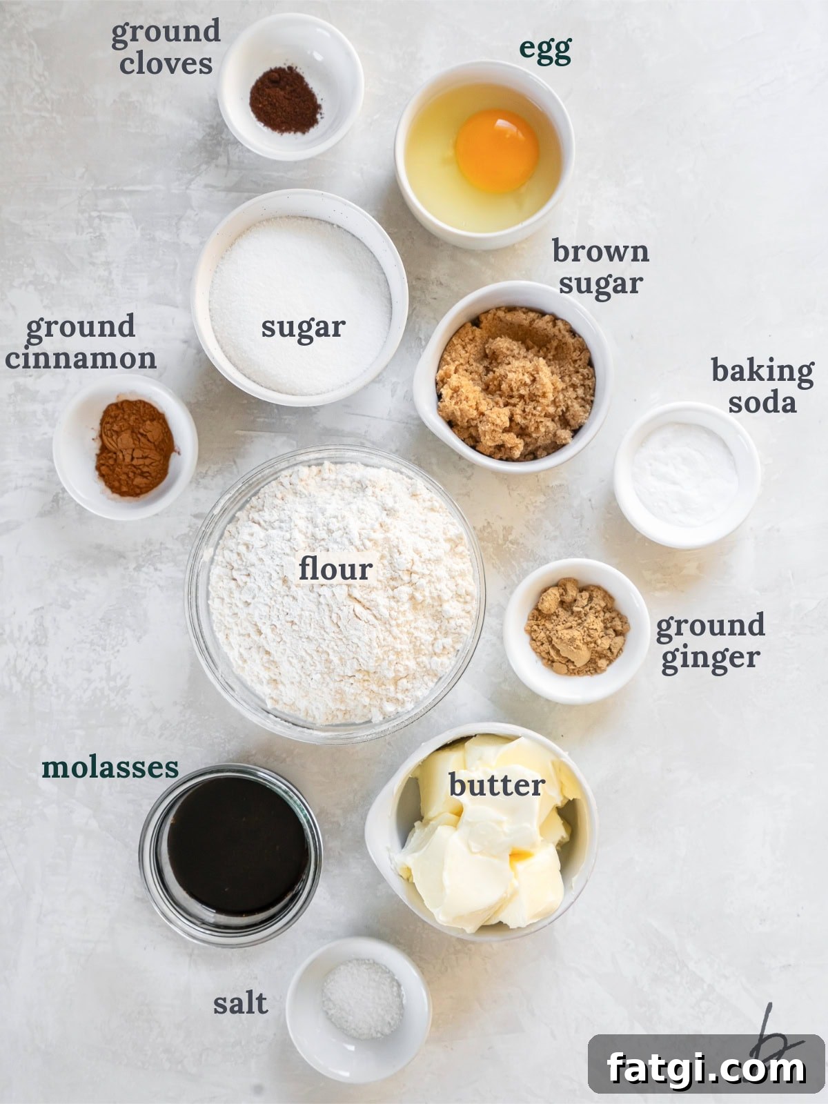 tabletop with bowls of ingredients to make gingersnap cookies.