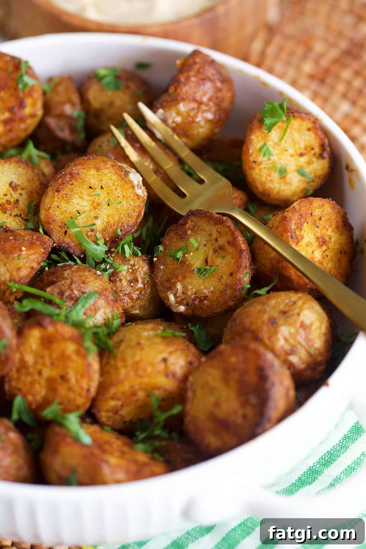 Air fryer roasted potatoes in a serving bowl with a fork