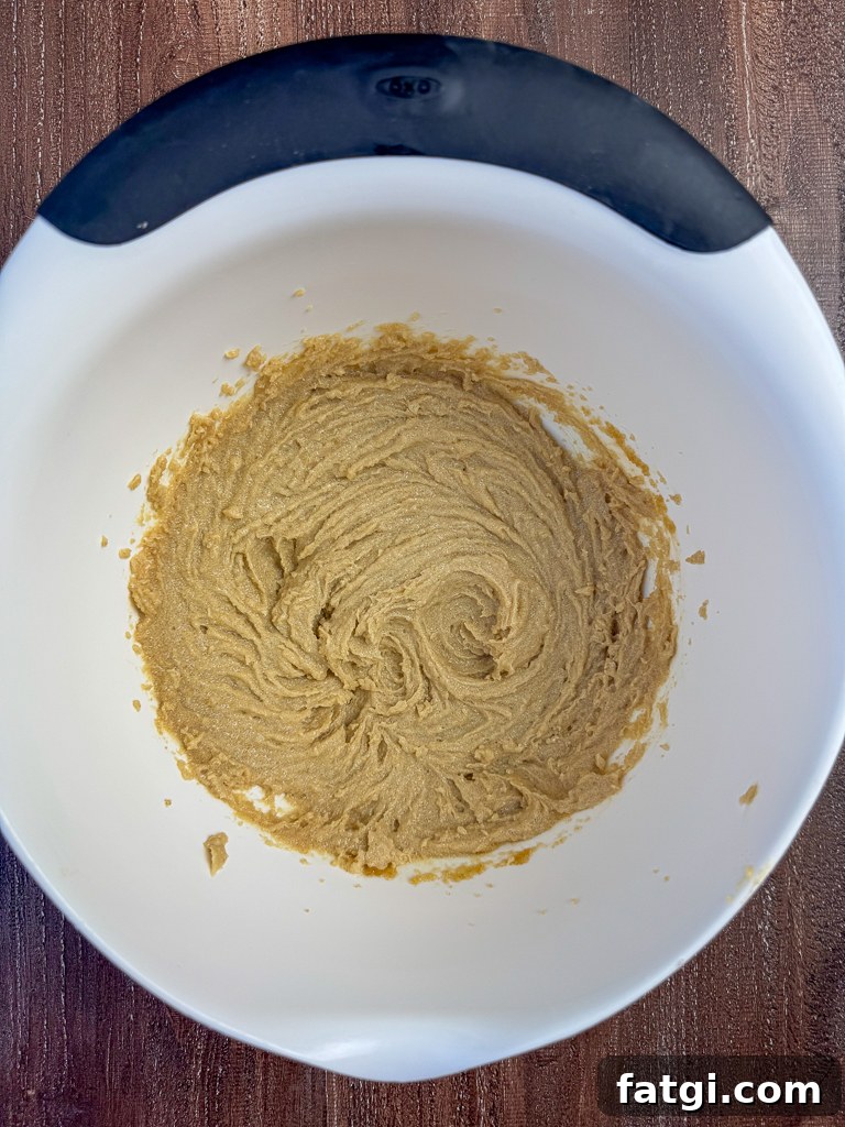 Brown sugar and butter beaten in a white mixing bowl until smooth.