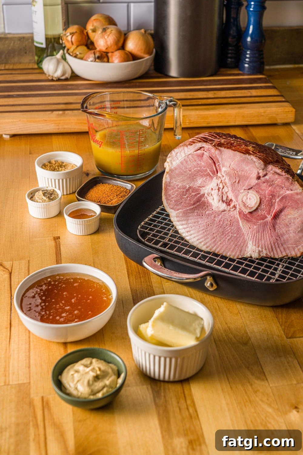 Spiral Ham with Pineapple and Brown Sugar Glaze 4 Ingredients to make glazed spiral ham including a spiral ham on a roasting pan lined with a rack, a bowl of honey, butter, mustard, pineapple juice, and seasonings.