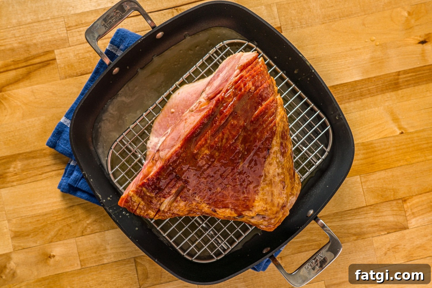 Spiral Ham with Pineapple and Brown Sugar Glaze 7 A glazed spiral ham on a roasting pan with a rack inside the pan.